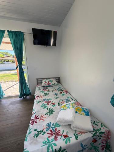 ein Schlafzimmer mit einem Bett und einem Fernseher an der Wand in der Unterkunft Makeanui Lodge 2 in Rangiroa