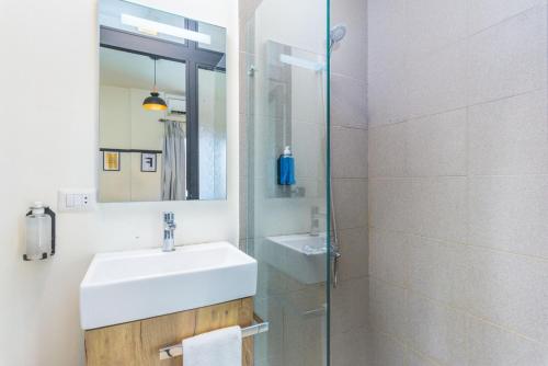 a bathroom with a sink and a shower with a mirror at Factory Studio in Mar Mikhael in Al Mudawwar