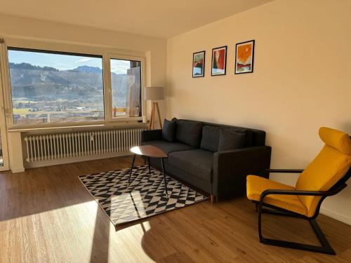 ein Wohnzimmer mit Sofa, Sessel und Fenster in der Unterkunft Panoramapause in Wertach