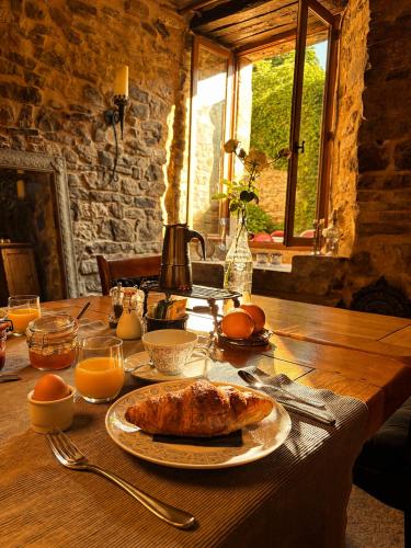 a wooden table with a plate of food on it at La Maison aux Puits in Cordes-sur-Ciel