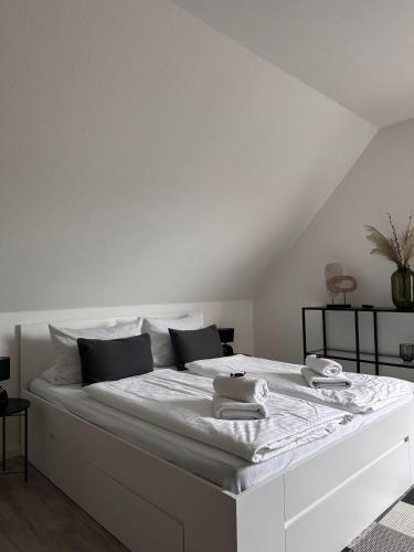 a white bed with white sheets and towels on it at Schönblick Apartments in Schönebeck