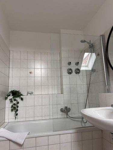 a bathroom with a bath tub and a sink at Schönblick Apartments in Schönebeck