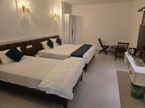 a hotel room with two beds and a sink at Hotel Ashok Vatika in Māharjhari