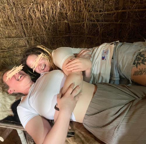 a group of three people laying on the ground at Akamba Traditional Grass Hut in Emali