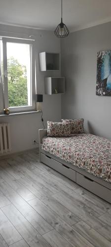 a bedroom with a bed and a window at Apartament w centrum in Biskupiec