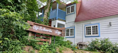 a house with a sign in front of it at Cafe&ResortInn VAIRGO in Hoki