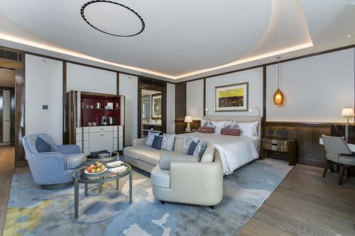 a hotel room with a bed and a couch and chairs at سما تعز in Şīnah