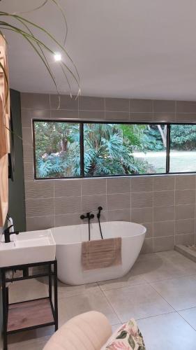 a large bathroom with a tub and a sink at Guesthouse Charis in Pretoria