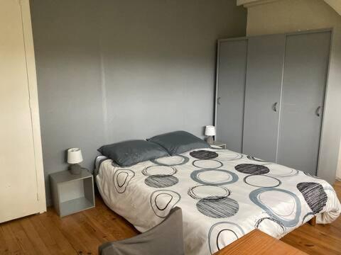 a bedroom with a bed and a chair in it at Chambre avec TV au calme in Pontgouin