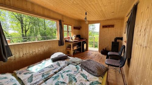 a bedroom with a bed and a desk and a window at Tiny house Modřínka in Nadějkov