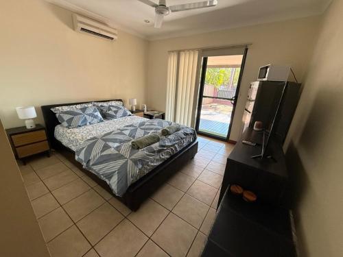 a bedroom with a bed and a television in it at Broome Rest House in Broome