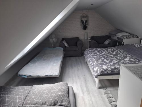 a attic room with two beds and a couch at Domek dwupoziomowy in Jarużyn