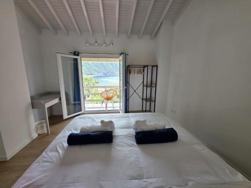 a large white bed in a room with a large window at Varadouro Cove House in Horta