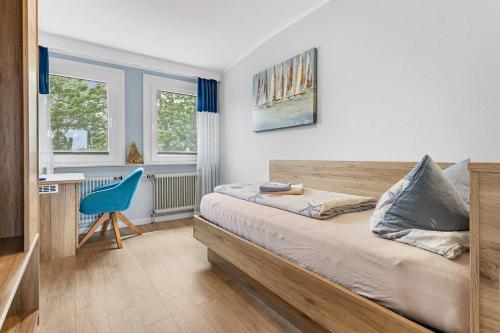 a bedroom with a bed and a desk and a chair at Hotel Norden Norddeich in Norddeich