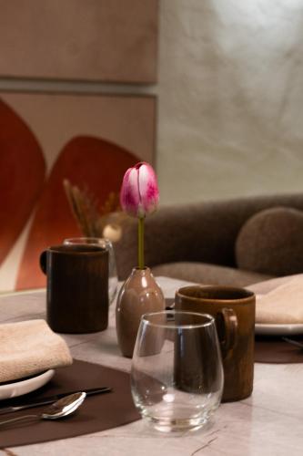 a pink flower in a vase on a table at Alnus in Valentano
