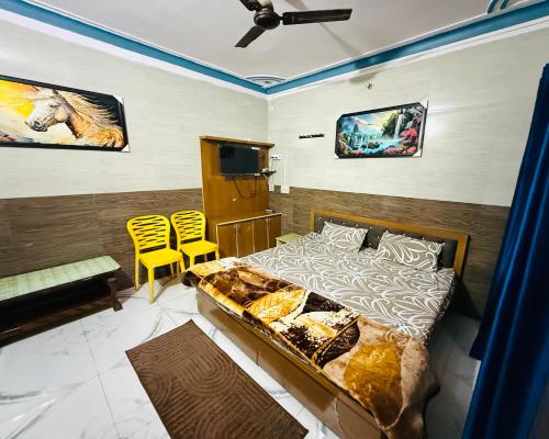 a bedroom with a bed and two yellow chairs at Hotel Blue Hill in Chamba