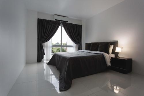 a bedroom with a bed and a large window at The One Apartment in Rawai Beach