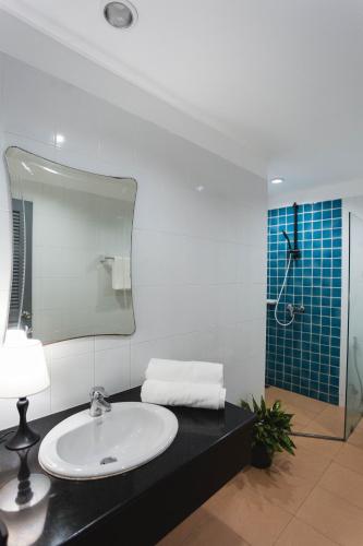 a bathroom with a sink and a mirror and a shower at The One Apartment in Rawai Beach