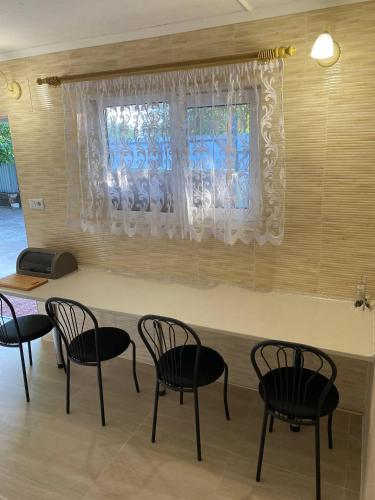 ein Zimmer mit Tisch und Stühlen und einem Fenster in der Unterkunft Язмін in Berehowe