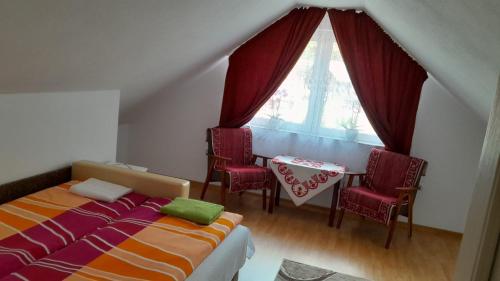 a bedroom with a bed and a table with chairs at Nagy Ildikó Vendégház in Lăzarea