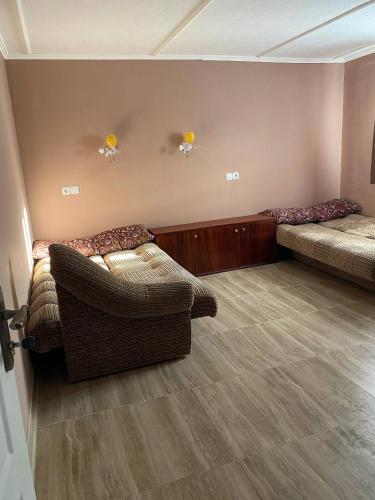 ein Zimmer mit zwei Betten und einem Stuhl in der Unterkunft Язмін in Berehowe