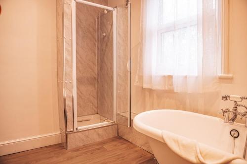 a bathroom with a shower and a bath tub at STAYtastic in Lowestoft
