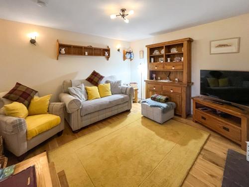 a living room with two couches and a tv at Bothan Aonghais in Portree