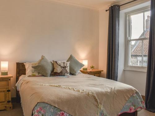 a bedroom with a large bed with a window at The Swiss Cottage in Pickering