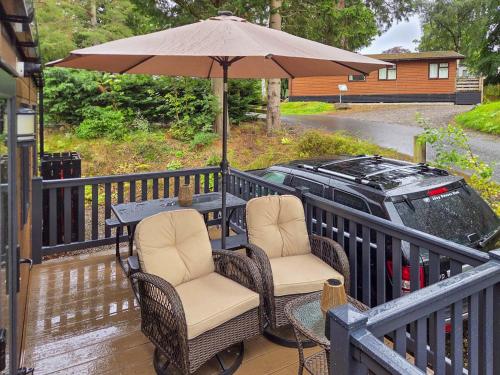 a table with two chairs and an umbrella on a porch at 1 Sunview Garden in Birnam