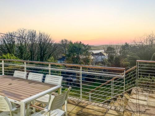 a patio with a table and chairs on a balcony at Cairn Ryan in Saint Mawes
