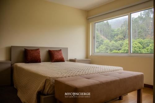 a bedroom with a bed and a large window at Quinta do Moinho in Castelo de Paiva