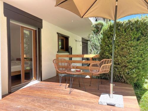a patio with a table and chairs and an umbrella at Apartment Eden Roc 53 by Interhome in Nendaz