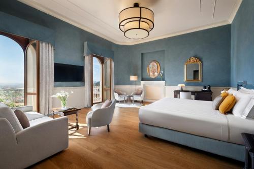 a bedroom with a large white bed and blue walls at Sina Brufani in Perugia