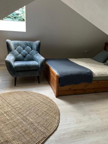 a bedroom with a bed and a chair and a rug at Apartament Morgan in Mieroszyno