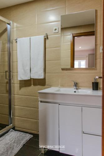 a bathroom with a sink and a mirror and a shower at Quinta do Moinho in Castelo de Paiva