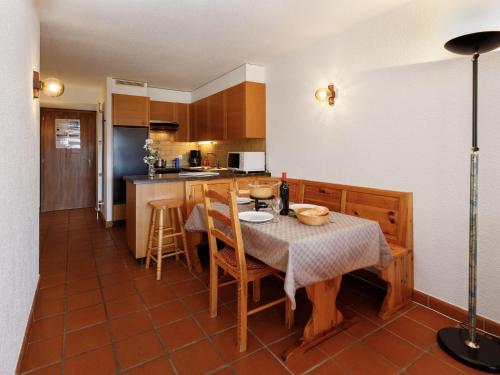 a kitchen with a table and chairs and a kitchen with a counter at Studio Terrasse Des Alpes 615 by Interhome in Vermala