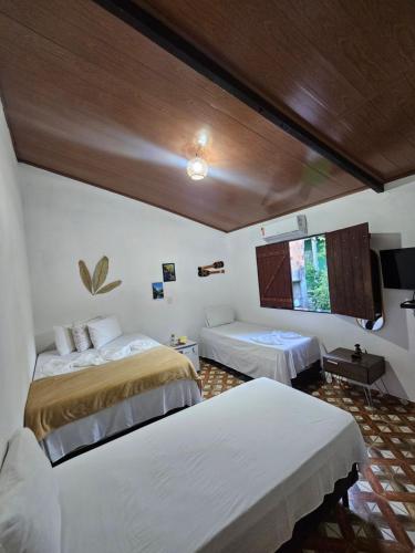 a bedroom with two beds and a window at Hospedaria Diamante Lençóis in Lençóis