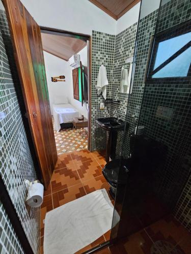 a bathroom with a shower and a sink in a room at Hospedaria Diamante Lençóis in Lençóis