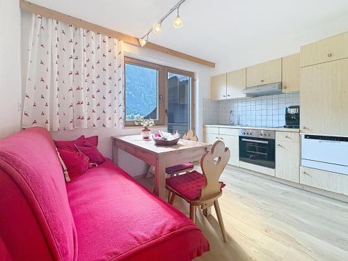 a living room with a pink couch and a table at Apartment Appartements Binderhof-1 by Interhome in Aschau