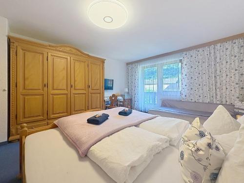 a bedroom with two beds and a large wooden cabinet at Apartment Appartements Binderhof-1 by Interhome in Aschau