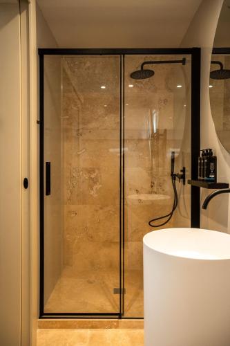 a shower with a glass door in a bathroom at The Three Doors in St. Julianʼs