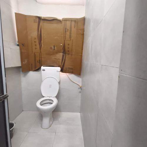 a bathroom with a toilet with boxes on the wall at Hotel My Home Dormitory in Boisar