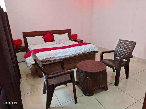 a bedroom with a bed and two chairs at Green Hotel in Jīnd
