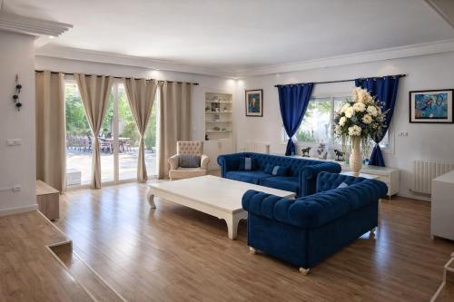 a living room with a blue couch and a table at Fantastic 6B Villa in Sidi Daoud