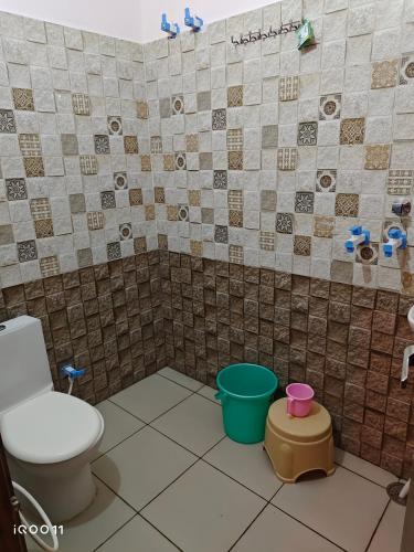 a bathroom with a toilet and some buckets at Green Hotel in Jīnd