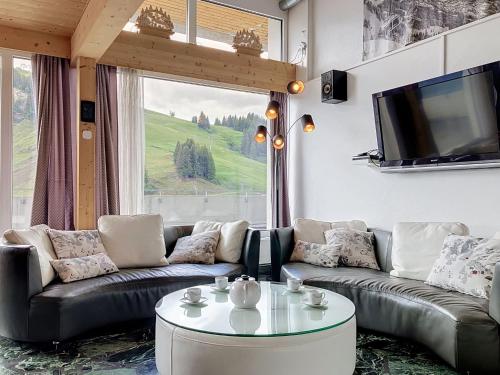 a living room with couches and a table and a tv at Apartment Les Cimes by Interhome in Les Crosets