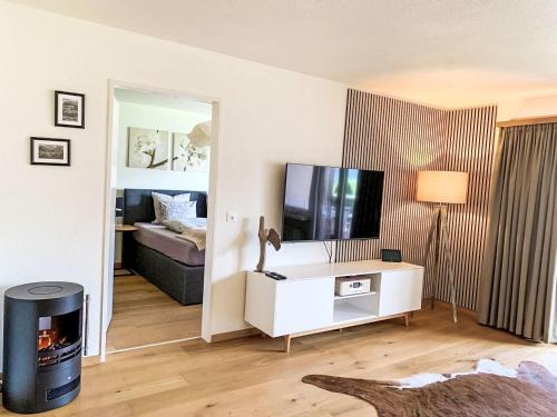 a living room with a tv and a room with a couch at Apartment Chäserruggblick by Interhome in Unterwasser