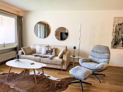 a living room with a couch and a chair at Apartment Chäserruggblick by Interhome in Unterwasser