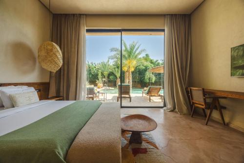 a bedroom with a bed and a view of a patio at Palais Nohe in Marrakesh