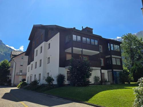 a large apartment building with a green yard at Apartment Dorfstrasse 53a by Interhome in Engelberg
